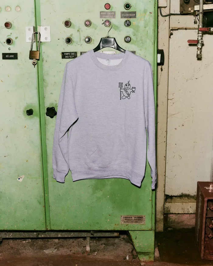 Grijze crewneck aan een haak in de brouwerij, met klein logo op de borst