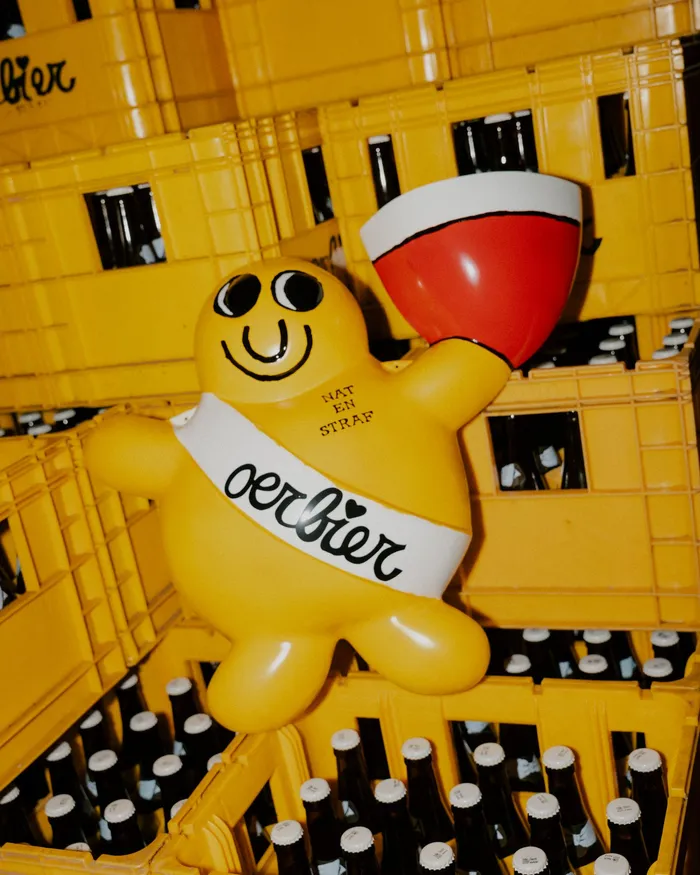 Geel Oerbier-mannetje met glas tussen bakken bier